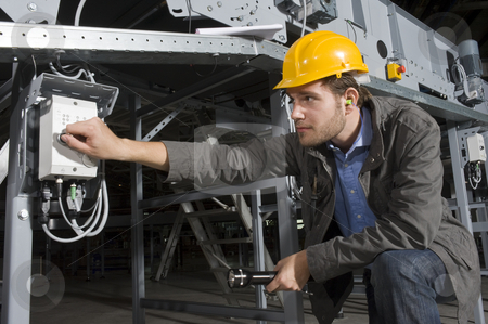 To use this stock image in your creative project, please select the size you need over to the right and click the "Add to Cart" button.
Your downloaded image will come with the Cutcaster watermark removed so don’t worry about the watermark you see on this page. Turning on stock photo, An engineer, wearing the proper safety equipment, turning on a machine by twisting a knob by Corepics VOF