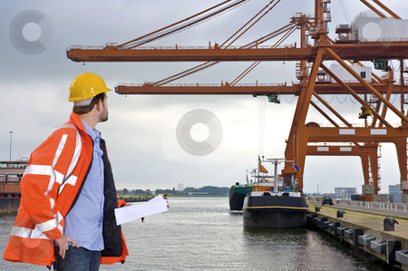 To use this stock image in your creative project, please select the size you need over to the right and click the "Add to Cart" button.
Your downloaded image will come with the Cutcaster watermark removed so don’t worry about the watermark you see on this page. Harbor Inspection stock photo, A man wearing a safety coat and a hard hat inspecting the huge cranes at a container harbor by Corepics VOF