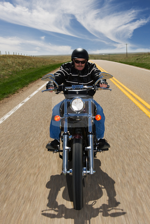 To use this stock image in your creative project, please select the size you need over to the right and click the "Add to Cart" button.
Your downloaded image will come with the Cutcaster watermark removed so don’t worry about the watermark you see on this page. Country travel stock photo, A biker taking a ride on a country highway by Steve Mcsweeny