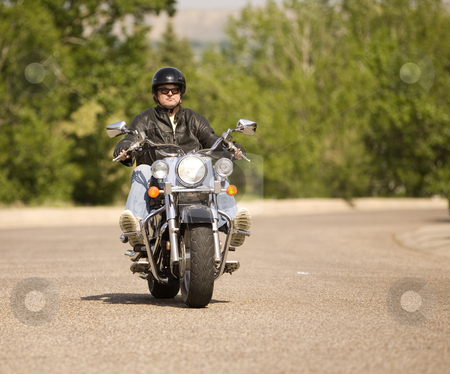 To use this stock image in your creative project, please select the size you need over to the right and click the "Add to Cart" button.
Your downloaded image will come with the Cutcaster watermark removed so don’t worry about the watermark you see on this page. Biker stock photo, Man out for a relaxing ride on his motorcycle by Steve Mcsweeny