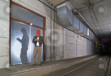 To use this stock image in your creative project, please select the size you need over to the right and click the "Add to Cart" button.
Your downloaded image will come with the Cutcaster watermark removed so don’t worry about the watermark you see on this page. Engineer with PDA stock photo, An Engineer in a dimly lit public transportation tunnel checking his Personal Digital Assistant by Corepics VOF