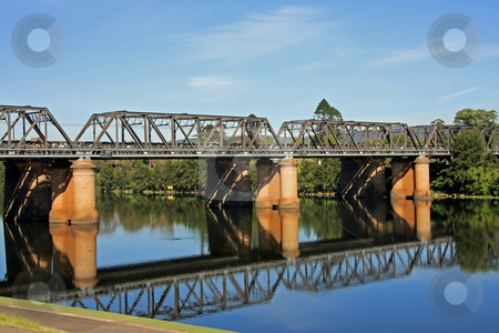 To use this stock image in your creative project, please select the size you need over to the right and click the "Add to Cart" button.
Your downloaded image will come with the Cutcaster watermark removed so don’t worry about the watermark you see on this page. Victoria Bridge stock photo, An old but still operable iron railway bridge erected over a river, complete with reflection. by Adam Goss