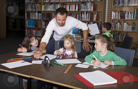 To use this stock image in your creative project, please select the size you need over to the right and click the "Add to Cart" button.
Your downloaded image will come with the Cutcaster watermark removed so don’t worry about the watermark you see on this page. Grade School stock photo, A teacher with his elementary students in the school library. by Brenda Carson