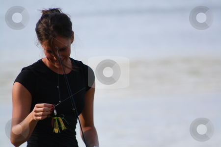 To use this stock image in your creative project, please select the size you need over to the right and click the "Add to Cart" button.
Your downloaded image will come with the Cutcaster watermark removed so don’t worry about the watermark you see on this page. A Beautiful Young Woman Fishing stock photo, Rebeka brings her tackle box and an open reel fishing pole for a day of fishing at the lake. by Chris Torres
