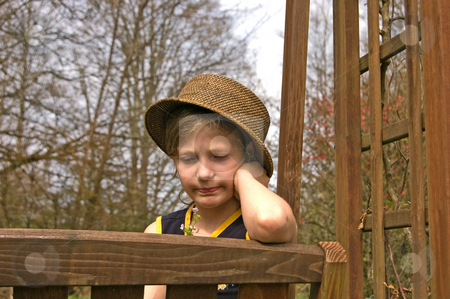 To use this stock image in your creative project, please select the size you need over to the right and click the "Add to Cart" button.
Your downloaded image will come with the Cutcaster watermark removed so don’t worry about the watermark you see on this page. Child on Garden Swing Sad stock photo, This child sitting on a garden swing is wearing a hat and looking at small flowers. Her facial expression is one of sadness and being upset. by Valerie Garner