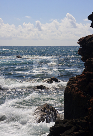 To use this stock image in your creative project, please select the size you need over to the right and click the "Add to Cart" button.
Your downloaded image will come with the Cutcaster watermark removed so don’t worry about the watermark you see on this page. Rocky headland and raging ocean stock photo, Backlit view of the raging ocean with a red craggy rock face on right by Steven Heap