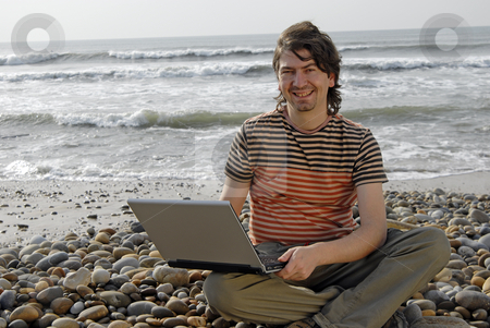 To use this stock image in your creative project, please select the size you need over to the right and click the "Add to Cart" button.
Your downloaded image will come with the Cutcaster watermark removed so don’t worry about the watermark you see on this page. Working stock photo, Young man at the beach with laptop by Rui Vale de Sousa