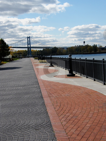 To use this stock image in your creative project, please select the size you need over to the right and click the "Add to Cart" button.
Your downloaded image will come with the Cutcaster watermark removed so don’t worry about the watermark you see on this page. Brick Sidewalk stock photo, Brick Sidewalk in Toledo Ohio along the Maumee River. Anthony Wayne Bridge (a.k.a. The High Level Bridge) off in the distance. by Dazz Lee Photography