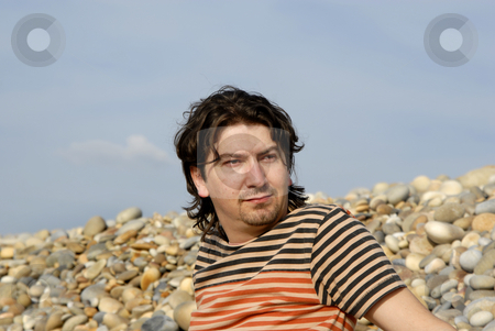 To use this stock image in your creative project, please select the size you need over to the right and click the "Add to Cart" button.
Your downloaded image will come with the Cutcaster watermark removed so don’t worry about the watermark you see on this page. Casual stock photo, Young casual man at the beach stones by Rui Vale de Sousa