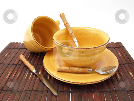 To use this stock image in your creative project, please select the size you need over to the right and click the "Add to Cart" button.
Your downloaded image will come with the Cutcaster watermark removed so don’t worry about the watermark you see on this page. Ready for Food stock photo, A ceramic bowl on a plate with a cup and utensils in thick earth tones atop a brown bamboo placemat. by Robert Gebbie
