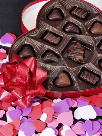 To use this stock image in your creative project, please select the size you need over to the right and click the "Add to Cart" button.
Your downloaded image will come with the Cutcaster watermark removed so don’t worry about the watermark you see on this page. Hearts stock photo, Multi colored heart cut outs spilled around a heart shaped box of chocolate candy. A shiny red bow completes the setting. by Robert Gebbie