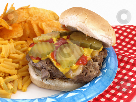 To use this stock image in your creative project, please select the size you need over to the right and click the "Add to Cart" button.
Your downloaded image will come with the Cutcaster watermark removed so don’t worry about the watermark you see on this page. Burger and Sides stock photo, Delicious picnic barbecue fare; homestyle burger; macaroni and cheese; and chips. Served on a paper blue plate; with disposable plastic fork and knife. by Robert Gebbie