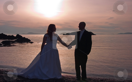 To use this stock image in your creative project, please select the size you need over to the right and click the "Add to Cart" button.
Your downloaded image will come with the Cutcaster watermark removed so don’t worry about the watermark you see on this page. Silhouette of Bride & Groom Holding Hands On Beach stock photo, This lovely photo is a silhouette of a bride and groom holding hands at sunset on a beach overlooking the ocean. by Valerie Garner
