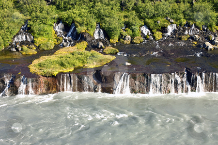 To use this stock image in your creative project, please select the size you need over to the right and click the "Add to Cart" button.
Your downloaded image will come with the Cutcaster watermark removed so don’t worry about the watermark you see on this page. Hraunfossar stock photo, The spectacular Hraunfossar cascades, a waterfall in Iceland, where natural springs supply the water from the rhyolite mountains, covered with shrubs, bushes, grass and moss. by Corepics VOF