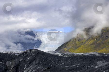 To use this stock image in your creative project, please select the size you need over to the right and click the "Add to Cart" button.
Your downloaded image will come with the Cutcaster watermark removed so don’t worry about the watermark you see on this page. Glimpse at the Glacier stock photo, A glimpse through the clouds on the Svinafellsjokull glacier, one of the arms of the famous Icelandic Ice cap, the Vatnajokull by Corepics VOF