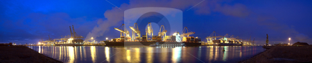 To use this stock image in your creative project, please select the size you need over to the right and click the "Add to Cart" button.
Your downloaded image will come with the Cutcaster watermark removed so don’t worry about the watermark you see on this page. Container Ship panorama stock photo, A panoramic image of three container ships being unloaded at night at a busy commercial harbour, with a small trawler moored alongside. by Corepics VOF