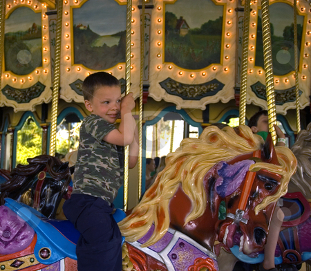 To use this stock image in your creative project, please select the size you need over to the right and click the "Add to Cart" button.
Your downloaded image will come with the Cutcaster watermark removed so don’t worry about the watermark you see on this page. Boy Riding A Carousel Merry Go Round stock photo, This little boy is riding a carousel merry go round and hanging on tightly to the pole. by Valerie Garner