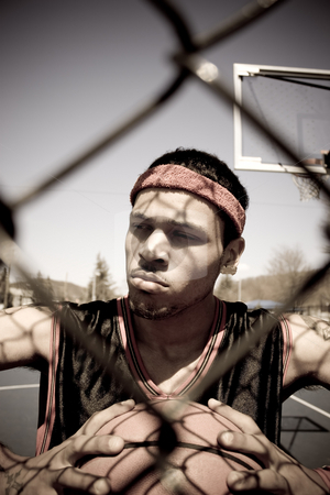 To use this stock image in your creative project, please select the size you need over to the right and click the "Add to Cart" button.
Your downloaded image will come with the Cutcaster watermark removed so don’t worry about the watermark you see on this page. Basketball Player stock photo, A young basketball player gripping the ball tightly as viewed through the chain linked fence. by Todd Arena