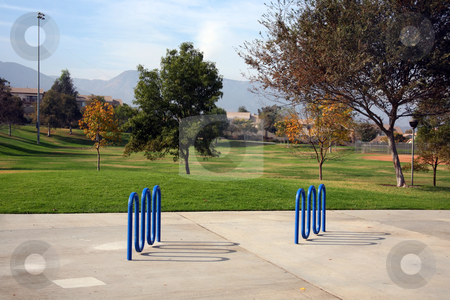 To use this stock image in your creative project, please select the size you need over to the right and click the "Add to Cart" button.
Your downloaded image will come with the Cutcaster watermark removed so don’t worry about the watermark you see on this page. Bike rack park stock photo, Blue bike racks set in concrete in a lovely park by Stacy Barnett