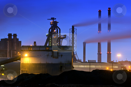 To use this stock image in your creative project, please select the size you need over to the right and click the "Add to Cart" button.
Your downloaded image will come with the Cutcaster watermark removed so don’t worry about the watermark you see on this page. Blast Furnace stock photo, The menacing outline of a blast furnace, surrounded by chimneys and the industrial appliances of a steel plant at night by Corepics VOF