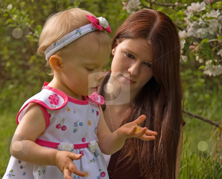 To use this stock image in your creative project, please select the size you need over to the right and click the "Add to Cart" button.
Your downloaded image will come with the Cutcaster watermark removed so don’t worry about the watermark you see on this page. Young Mom and Toddler Looking at Flower stock photo, This young mom is watching her toddler girl hold and look at a buttercup flower outside. by Valerie Garner