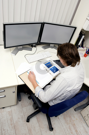 To use this stock image in your creative project, please select the size you need over to the right and click the "Add to Cart" button.
Your downloaded image will come with the Cutcaster watermark removed so don’t worry about the watermark you see on this page. Studying a dossier stock photo, An engineer studying a thick dossier behind his desk with two computer screens on it by Corepics VOF