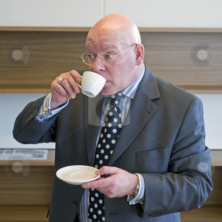 To use this stock image in your creative project, please select the size you need over to the right and click the "Add to Cart" button.
Your downloaded image will come with the Cutcaster watermark removed so don’t worry about the watermark you see on this page. Sipping coffee stock photo, A senior manager sipping coffee and looking up from behind his cup at what is going on around him by Corepics VOF