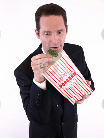 To use this stock image in your creative project, please select the size you need over to the right and click the "Add to Cart" button.
Your downloaded image will come with the Cutcaster watermark removed so don’t worry about the watermark you see on this page. Broccoli Surprise stock photo, A man in a black suit pulls a piece of broccoli from a popcorn bag. Over white. by Robert Gebbie