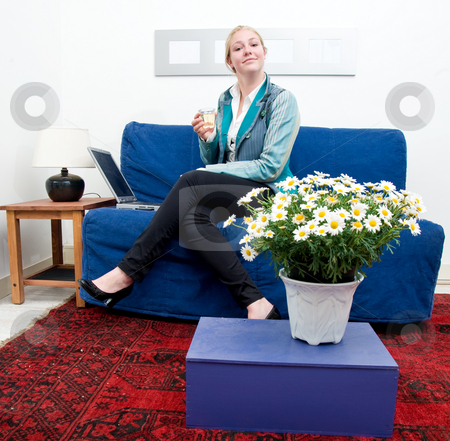To use this stock image in your creative project, please select the size you need over to the right and click the "Add to Cart" button.
Your downloaded image will come with the Cutcaster watermark removed so don’t worry about the watermark you see on this page. Smiling woman stock photo, Portrait of a broadly smiling woman with laptop, holding a glass of white wine on a couch by Corepics VOF
