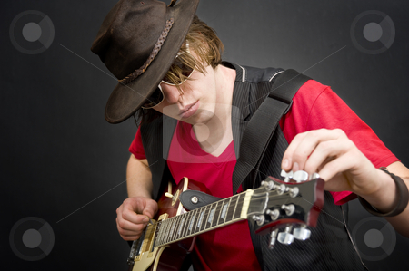 To use this stock image in your creative project, please select the size you need over to the right and click the "Add to Cart" button.
Your downloaded image will come with the Cutcaster watermark removed so don’t worry about the watermark you see on this page. Tuning a guitar stock photo, A cool looking guitar player tuning his instrument by Corepics VOF