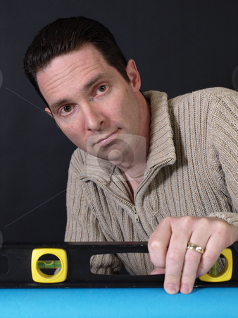 To use this stock image in your creative project, please select the size you need over to the right and click the "Add to Cart" button.
Your downloaded image will come with the Cutcaster watermark removed so don’t worry about the watermark you see on this page. Man using Level stock photo, A man holding a level checks to make sure his project is straight. by Robert Gebbie