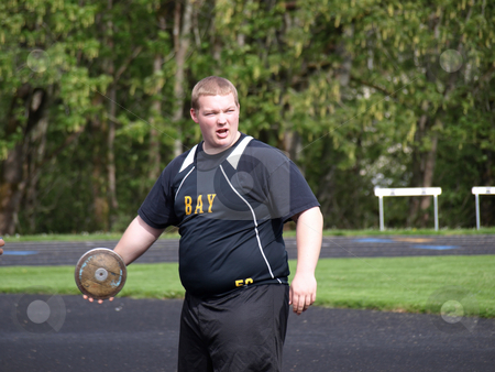 To use this stock image in your creative project, please select the size you need over to the right and click the "Add to Cart" button.
Your downloaded image will come with the Cutcaster watermark removed so don’t worry about the watermark you see on this page. Teen Athlete with Discus stock photo, A teenage athlete holds the discus in one hand as he warms up for his toss. by Robert Gebbie
