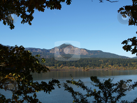 To use this stock image in your creative project, please select the size you need over to the right and click the "Add to Cart" button.
Your downloaded image will come with the Cutcaster watermark removed so don’t worry about the watermark you see on this page. Mountain in Distance stock photo, Washington State landscape image of lake or river with mountain in background. Framed close by trees on the banks. by Robert Gebbie