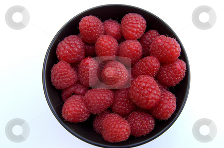 To use this stock image in your creative project, please select the size you need over to the right and click the "Add to Cart" button.
Your downloaded image will come with the Cutcaster watermark removed so don’t worry about the watermark you see on this page. Raspberries in bowl stock photo, Overhead shot of fresh red raspberries in black bowl on white background by Christian Rhein