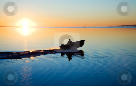 To use this stock image in your creative project, please select the size you need over to the right and click the "Add to Cart" button.
Your downloaded image will come with the Cutcaster watermark removed so don’t worry about the watermark you see on this page. Pacific Northwest Sunset stock photo, A man in a boat at Cline Spit in Sequim Washington. by Travis Manley