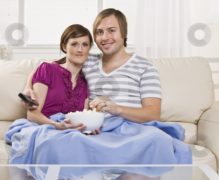 To use this stock image in your creative project, please select the size you need over to the right and click the "Add to Cart" button.
Your downloaded image will come with the Cutcaster watermark removed so don’t worry about the watermark you see on this page. Attractive couple eating popcorn. stock photo, Attractive couple eating popcorn on the coach with blanket and holding a remote. Horizontal. by Jonathan Ross