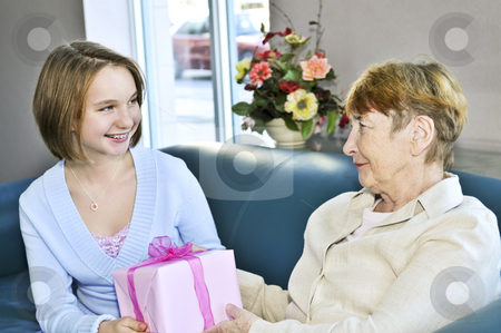 To use this stock image in your creative project, please select the size you need over to the right and click the "Add to Cart" button.
Your downloaded image will come with the Cutcaster watermark removed so don’t worry about the watermark you see on this page. Granddaughter visiting grandmother stock photo, Granddaughter giving a present to her grandmother by Elena Elisseeva