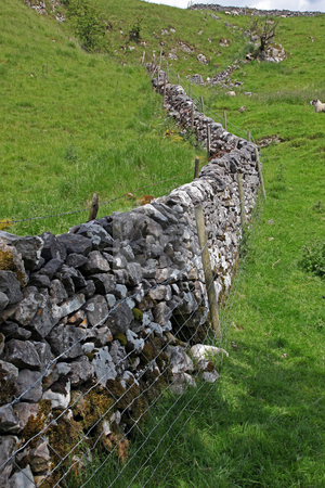 To use this stock image in your creative project, please select the size you need over to the right and click the "Add to Cart" button.
Your downloaded image will come with the Cutcaster watermark removed so don’t worry about the watermark you see on this page. Dry stone wall in Derbyshire England stock photo, In the hills of England dry stone walls are made to divide fields as no hedges will grow in the shallow soil. by Ian Langley