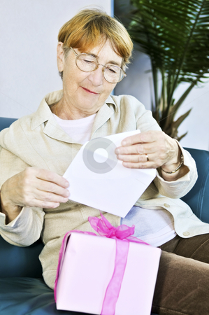 To use this stock image in your creative project, please select the size you need over to the right and click the "Add to Cart" button.
Your downloaded image will come with the Cutcaster watermark removed so don’t worry about the watermark you see on this page. Old woman opening present stock photo, Elderly woman opening birthday card and present by Elena Elisseeva