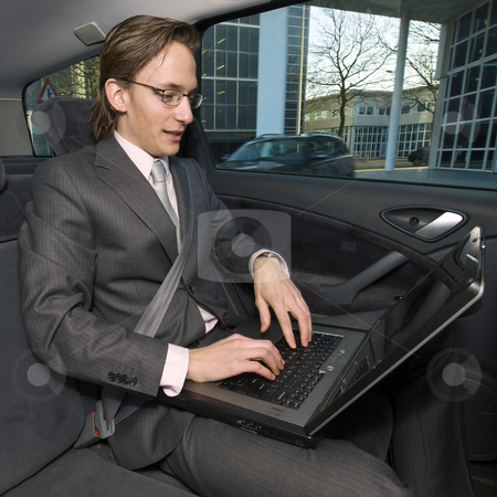To use this stock image in your creative project, please select the size you need over to the right and click the "Add to Cart" button.
Your downloaded image will come with the Cutcaster watermark removed so don’t worry about the watermark you see on this page. Working in a taxi stock photo, A businessman working in the backseat of a taxi being driven through a financial district by Corepics VOF