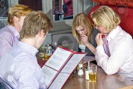 To use this stock image in your creative project, please select the size you need over to the right and click the "Add to Cart" button.
Your downloaded image will come with the Cutcaster watermark removed so don’t worry about the watermark you see on this page. Chosing from a menu stock photo, A group of four people chosing dishes from the menu in a restaurant by Corepics VOF