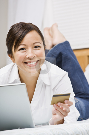 To use this stock image in your creative project, please select the size you need over to the right and click the "Add to Cart" button.
Your downloaded image will come with the Cutcaster watermark removed so don’t worry about the watermark you see on this page. Beautiful Asian Woman with Credit Card stock photo, Beautiful asian woman holding a credit card and using a laptop. She is smiling at the camera. Vertically framed shot. by Jonathan Ross