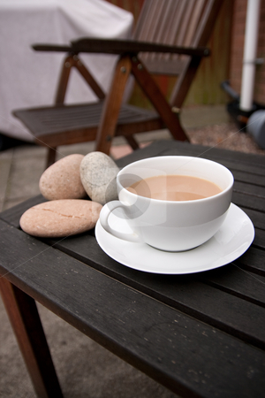 To use this stock image in your creative project, please select the size you need over to the right and click the "Add to Cart" button.
Your downloaded image will come with the Cutcaster watermark removed so don’t worry about the watermark you see on this page. Cup of Tea stock photo, Outdoor cup of tea in a white cup and saucer with stones on a wooden background by Keith Wilson