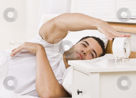 To use this stock image in your creative project, please select the size you need over to the right and click the "Add to Cart" button.
Your downloaded image will come with the Cutcaster watermark removed so don’t worry about the watermark you see on this page. Man with Alarm Clock stock photo, A man lying in bed. He is reaching his arm to touch an alarm clock. He looks tired. Horizontally framed shot. by Jonathan Ross