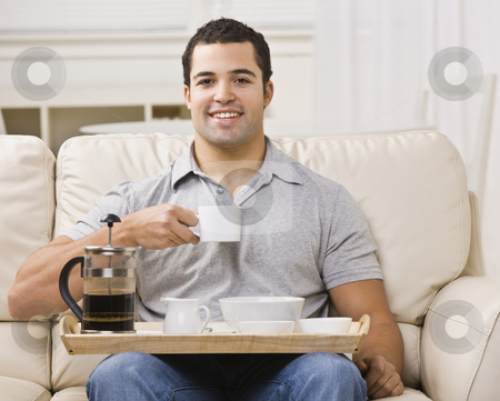 To use this stock image in your creative project, please select the size you need over to the right and click the "Add to Cart" button.
Your downloaded image will come with the Cutcaster watermark removed so don’t worry about the watermark you see on this page. Man with Breakfast Tray and Coffee stock photo, An attractive young man eating from a breakfast tray. He has a coffee cup raised, and is smiling directly at the camera. Horizontally framed photo. by Jonathan Ross