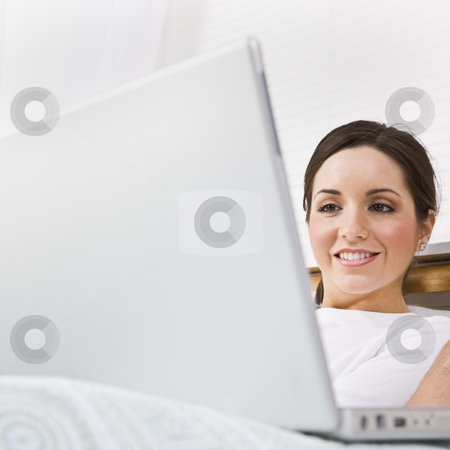 To use this stock image in your creative project, please select the size you need over to the right and click the "Add to Cart" button.
Your downloaded image will come with the Cutcaster watermark removed so don’t worry about the watermark you see on this page. Beautiful Woman Using Laptop stock photo, A beautiful young woman is sitting in a room and working on a laptop. She is smiling and is looking at the screen. Square framed shot. by Jonathan Ross