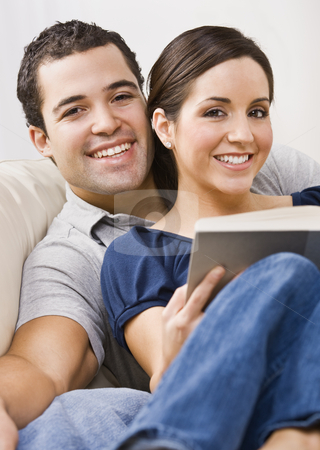 To use this stock image in your creative project, please select the size you need over to the right and click the "Add to Cart" button.
Your downloaded image will come with the Cutcaster watermark removed so don’t worry about the watermark you see on this page. Couple Relaxing stock photo, An attractive young couple relaxing together. The female is holding a book and they are smiling directly at the camera. Vertically framed photo. by Jonathan Ross