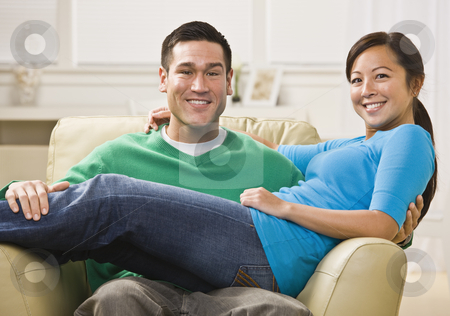 To use this stock image in your creative project, please select the size you need over to the right and click the "Add to Cart" button.
Your downloaded image will come with the Cutcaster watermark removed so don’t worry about the watermark you see on this page. Attractive Smiling Couple on Sofa stock photo, Attractive Asian Couple relaxing together on their living room couch. Horizontally framed photo. by Jonathan Ross