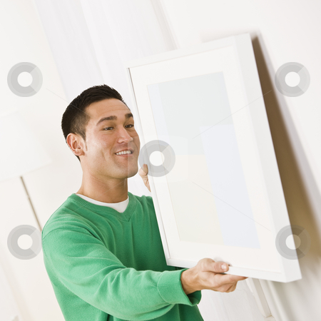 To use this stock image in your creative project, please select the size you need over to the right and click the "Add to Cart" button.
Your downloaded image will come with the Cutcaster watermark removed so don’t worry about the watermark you see on this page. Asian male hanging art stock photo, Asian male wearing a green sweater hanging art on wall. Square composition by Jonathan Ross