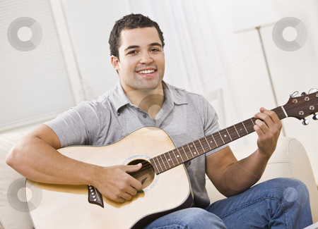 To use this stock image in your creative project, please select the size you need over to the right and click the "Add to Cart" button.
Your downloaded image will come with the Cutcaster watermark removed so don’t worry about the watermark you see on this page. Attractive Man with Guitar stock photo, An attractive young man playing the guitar. He is seated on a couch and is smiling at the camera. Horizontally framed shot. by Jonathan Ross